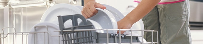 孩子将碗碟装入洗碗机