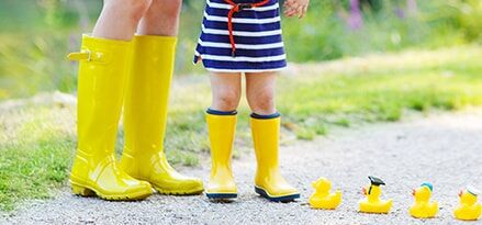 妈妈和孩子站在小道上的橡胶鸭旁