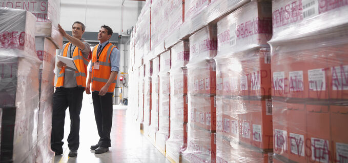 Two men in warehouse looking at PPS film